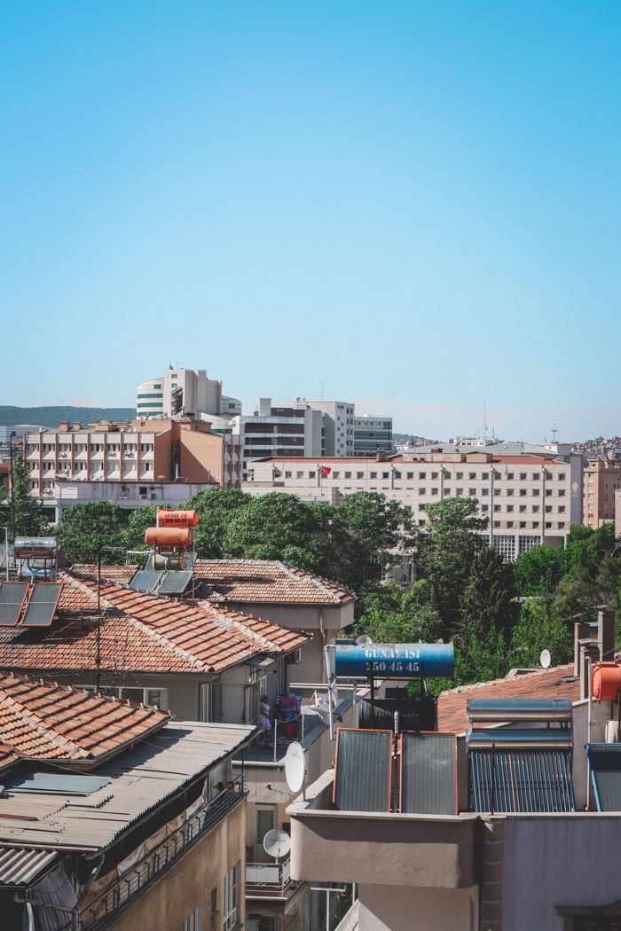 View of Gaziantep showcasing traditional rooftops and modern buildings against a clear blue sky.